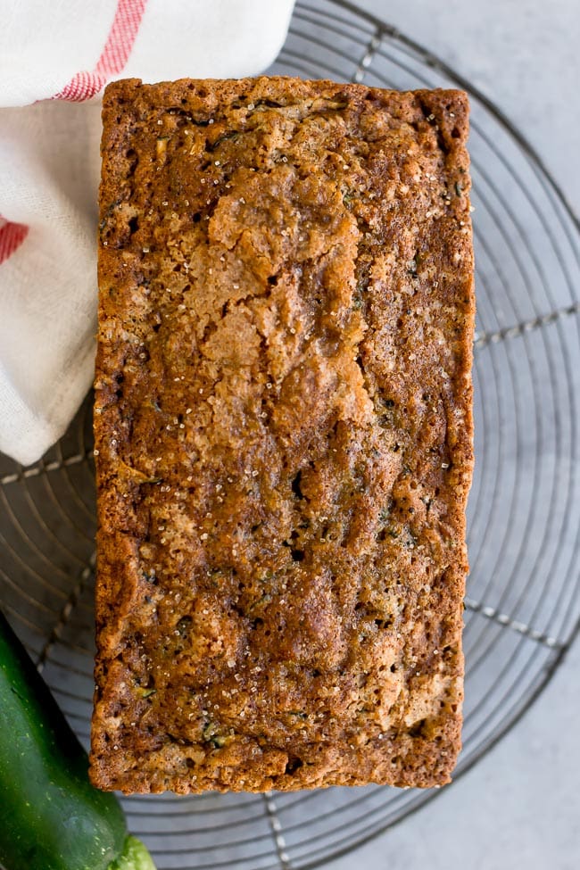 The BEST zucchini bread recipe! Use your garden zucchini to make this easy zucchini bread recipe! #zucchinibread #zucchini #bread #quickbread #baking #summer #easyrecipe loaf of zucchini bread cooling on wire cooling rack.