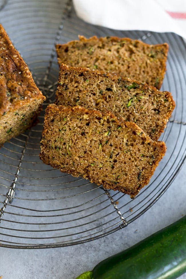 This Classic Zucchini Bread Is The BEST Zucchini Bread Recipe! It Is Easy To Make, Perfectly Spiced, And The Zucchini Bread Is Super Moist! The Best Way To Use Up Your Garden Zucchini. #zucchini #zucchinibread #summer #recipe #easyrecipe #bread #quickbread #vegetarian Zucchini Bread sliced on cooling rack.