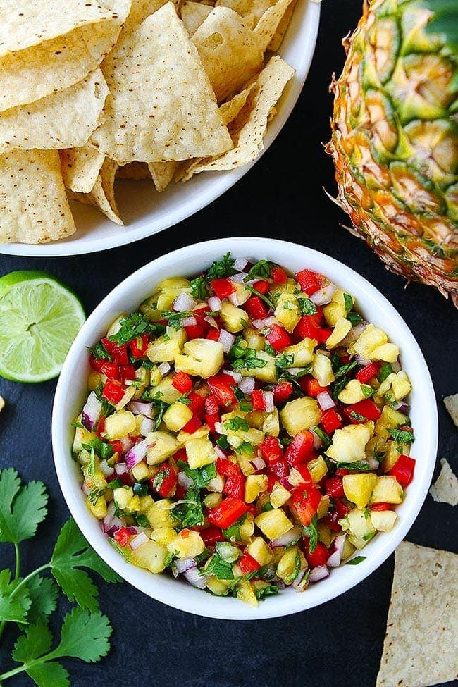 This fresh and simple Pineapple Salsa goes great with fish, chicken, tacos, or tortilla chips! #pineapple #salsa #summer #easyrecipe #glutenfree #vegan #vegetarian fresh pineapple salsa in bowl with chips.