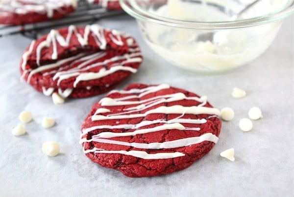 Red Velvet Cheesecake Cookies-you will love the cheesecake surprise inside! #redvelvet #cheesecake #cookies Red Velvet Cookie Recipe with bowl of frosting