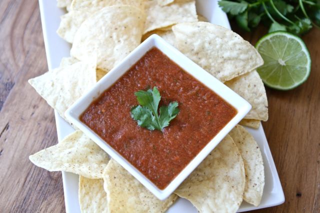 Restaurant Style Salsa Recipe on twopeasandtheirpod.com LOVE this easy blender salsa! It makes a big batch too! Plated chips and homemade salsa made from easy salsa recipe