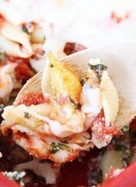 Baked pasta shells on wooden spoon