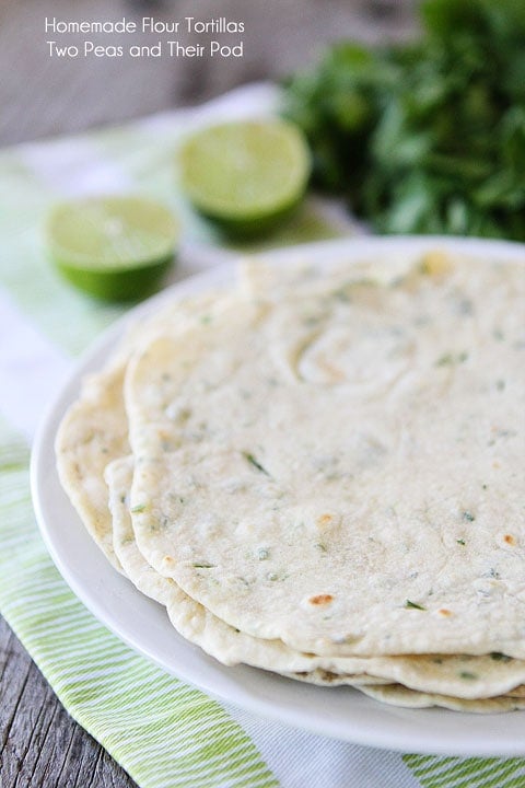 Homemade Flour Tortillas Recipe on twopeasandtheirpod.com Easy to make at home and so much better than store bought tortillas! Cilantro Lime Homemade Tortillas on plate