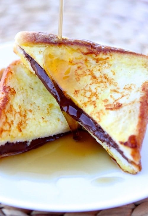 Nutella Stuffed French Toast Recipe Nutella Stuffed French Toast Recipe on twopeasandtheirpod.com. This decadent French toast recipe will send you into a happy sugar coma!