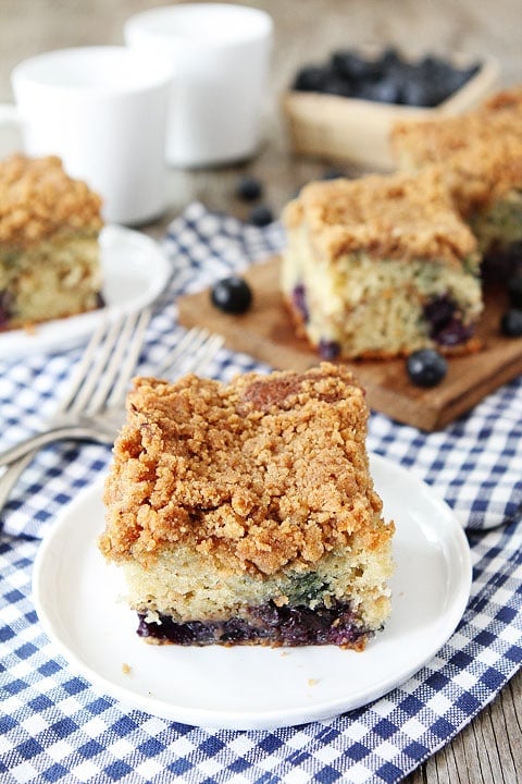 Blueberry Coffee Cake Recipe on twopeasandtheirpod.com. This cake is great for breakfast or dessert! #cake Blueberry Coffee Cake Slice on Plate