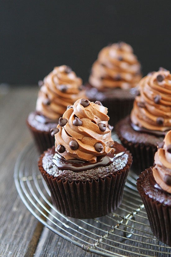 Ultimate Chocolate Cupcake Recipe on twopeasandtheirpod.com Chocolate cupcakes with silky chocolate ganache and the most amazing chocolate buttercream frosting! Half dozen of the best chocolate cupcakes on cooling rack