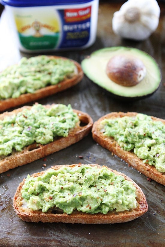Garlic Bread Avocado Toasts Recipe on twopeasandtheirpod.com Buttery garlic bread with mashed avocado, sea salt, and pepper! This garlic bread is easy to make and SO good! Completed Garlic Bread Avocado Toast Recipe