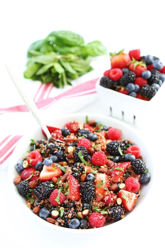 Berry Quinoa Salad Recipe on twopeasandtheirpod.com This healthy fruit salad is a summer favorite! Eat it for breakfast or serve at your next summer BBQ! Berry Quinoa Salad with almonds in bowl with spoon.