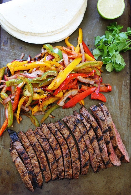 Grilled Steak Fajitas Recipe on twopeasandtheirpod.com Get out the grill and make these easy and delicious fajitas for dinner! Easy steak fajitas laid out and ready to assemble
