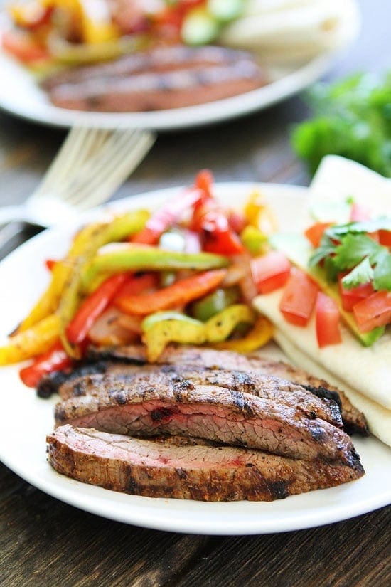 Grilled Steak Fajitas Recipe on twopeasandtheirpod.com Get out the grill and make these easy and delicious fajitas for dinner! Serve with tortillas and your favorite toppings! Grilled Steak Fajitas on plate