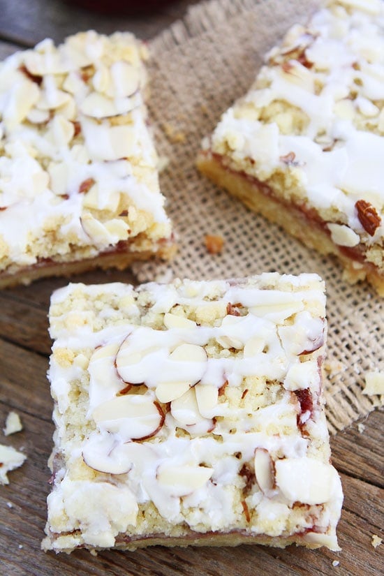 Raspberry Almond Shortbread Bars Recipe on twopeasandtheirpod.com Buttery shortbread bars with raspberry jam, almond streusel, and a sweet almond glaze! Raspberry Almond Shortbread Bars Recipe
