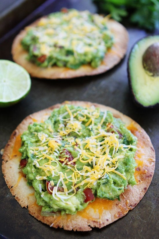 Cheesy Guacamole Tostadas Recipe on twopeasandtheirpod.com These easy and cheesy tostadas only take 20 minutes to make! They are great for an easy dinner or snack! Cheesy Guacamole Tostada