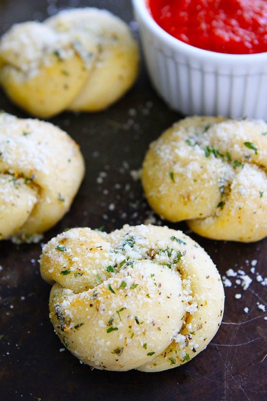 Garlic Knots Recipe on twopeasandtheirpod.com Buttery garlic knots made with pre-made pizza dough! Easy, cheesy, and SO good! Homemade Garlic Knots with marinara sauce