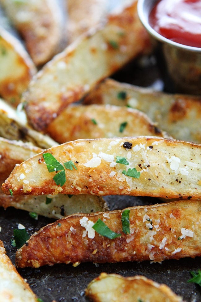 Baked Garlic Parmesan Potato Wedges Recipe on twopeasandtheirpod.com You will never know these fries are made in the oven! They are crispy and SO delicious! Baked Potato Wedges with garlic and parmesan