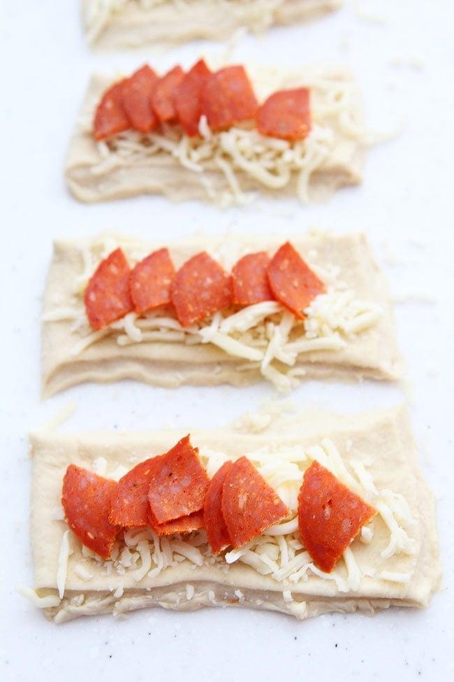 Pepperoni Pizza Rolls Recipe on twopeasandtheirpod.com Easy pizza rolls stuffed with pepperoni, cheese, and brushed with garlic butter. Everyone loves these easy pizza rolls! how to make pizza rolls with pepperoni