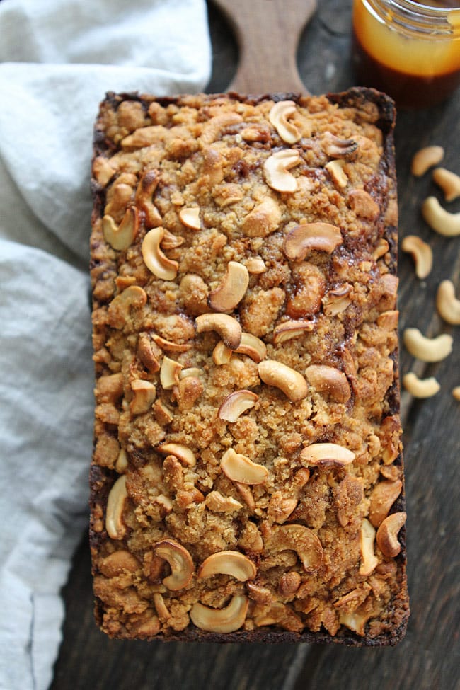 Salted Caramel Cashew Banana Bread Recipe on twopeasandtheirpod.com This banana bread is amazing! It has a swirl of salted caramel sauce and a cashew streusel topping! Salted Caramel Cashew Banana Bread Recipe