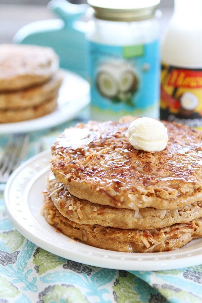 Toasted Coconut Pancakes Recipe on twopeasandtheirpod.com Light and fluffy pancakes with a sweet toasted coconut topping! Coconut Pancakes served with coconut syrup and butter