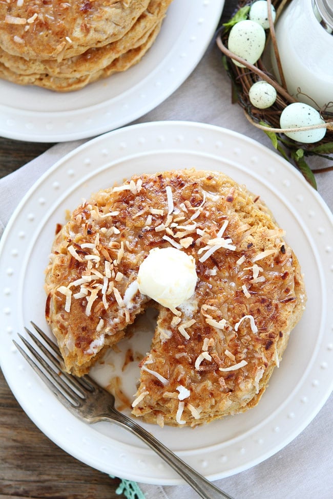 Toasted Coconut Pancakes Recipe on twopeasandtheirpod.com Light and fluffy pancakes with a sweet toasted coconut topping! Our family LOVES these pancakes! Coconut milk Pancakes served on white plate