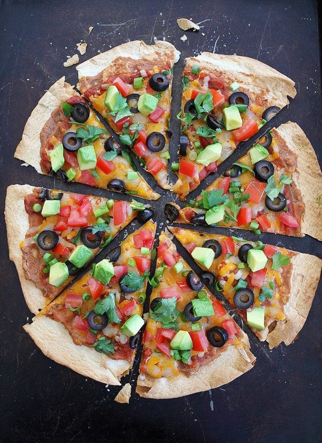 Crispy Mexican Tortilla Pizza Recipe on twopeasandtheirpod.com You can have this easy pizza on your dinner table in 15 minutes. Slices of Crispy Mexican Tortilla Pizza
