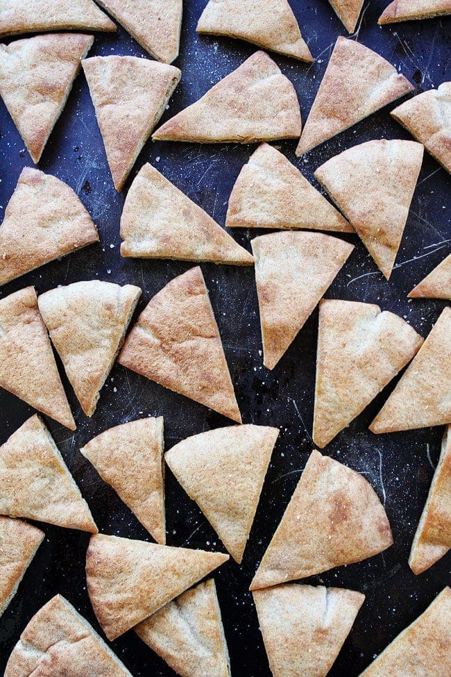 Homemade Pita Chips Recipe on twopeasandtheirpod.com Pita chips are easy to make at home and they taste much better than store bought chips! Homemade Pita Chips on baking sheet.