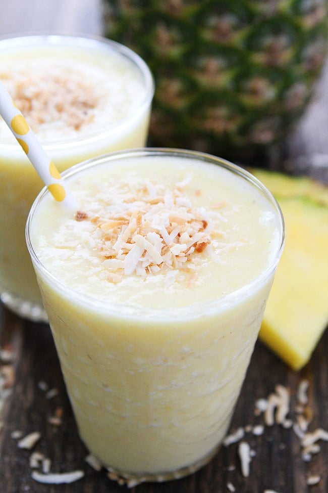 Pineapple Coconut Smoothie Recipe on twopeasandtheirpod.com This simple and healthy smoothie is so refreshing and will make you feel like you are in paradise! Pineapple Coconut Smoothie in glass with toasted coconut on top