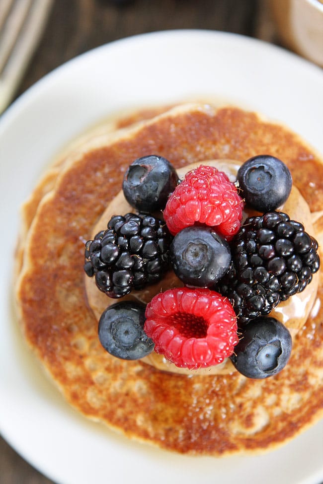 Almond Butter Pancakes Recipe on twopeasandtheirpod.com These whole wheat protein pancakes make a great healthy breakfast! They are the perfect start to any day! Almond Butter Pancakes with berries on plate with fork