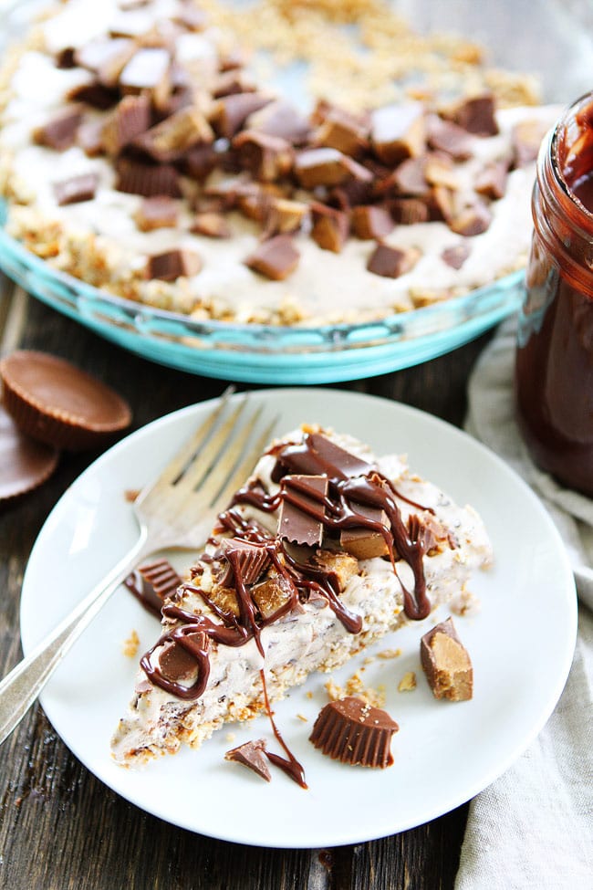 Peanut Butter Pretzel Ice Cream Pie Recipe on twopeasandtheirpod.com A salty pretzel crust filled with Moose Tracks ice cream then topped with peanut butter cups and drizzled with peanut butter hot fudge sauce! This pie is the ultimate summer dessert! Peanut Butter Pretzel Ice Cream Pie Recipe