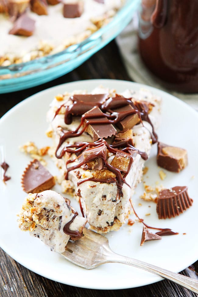 Peanut Butter Pretzel Ice Cream Pie Recipe on twopeasandtheirpod.com A salty pretzel crust filled with Moose Tracks ice cream then topped with peanut butter cups and drizzled with peanut butter hot fudge sauce! This sweet and salty ice cream pie is amazing! Peanut Butter Pretzel Ice Cream Pie Recipe
