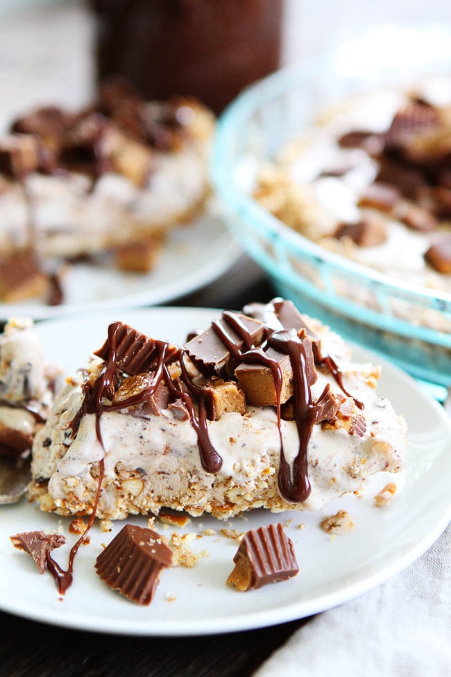 Peanut Butter Pretzel Ice Cream Pie Recipe on twopeasandtheirpod.com A salty pretzel crust filled with Moose Tracks ice cream then topped with peanut butter cups and drizzled with peanut butter hot fudge sauce! This pie is our FAVORITE dessert! Peanut Butter Pretzel Ice Cream Pie Recipe