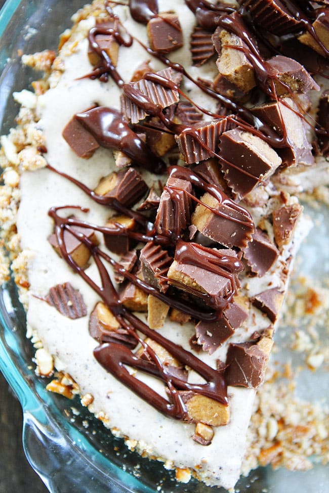 Peanut Butter Pretzel Ice Cream Pie Recipe on twopeasandtheirpod.com A salty pretzel crust filled with Moose Tracks ice cream then topped with peanut butter cups and drizzled with peanut butter hot fudge sauce! This is the BEST pie and it's SO easy to make! Peanut Butter Pretzel Ice Cream Pie Recipe