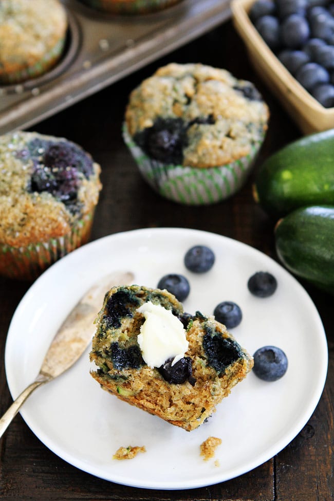 Zucchini Banana Blueberry Muffin Recipe on twopeasandtheirpod.com Our family loves these nutritious and delicious muffins! They are sure to be a favorite at your house too! Zucchini Banana Blueberry Muffin with butter on plate.