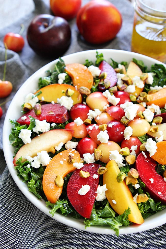 Stone Fruit Kale Salad Recipe on twopeasandtheirpod.com This simple kale salad is loaded with summer stone fruit, goat cheese, and pistachios. It is the perfect side to all of your summer meals. Stone Fruit Kale Salad Recipe