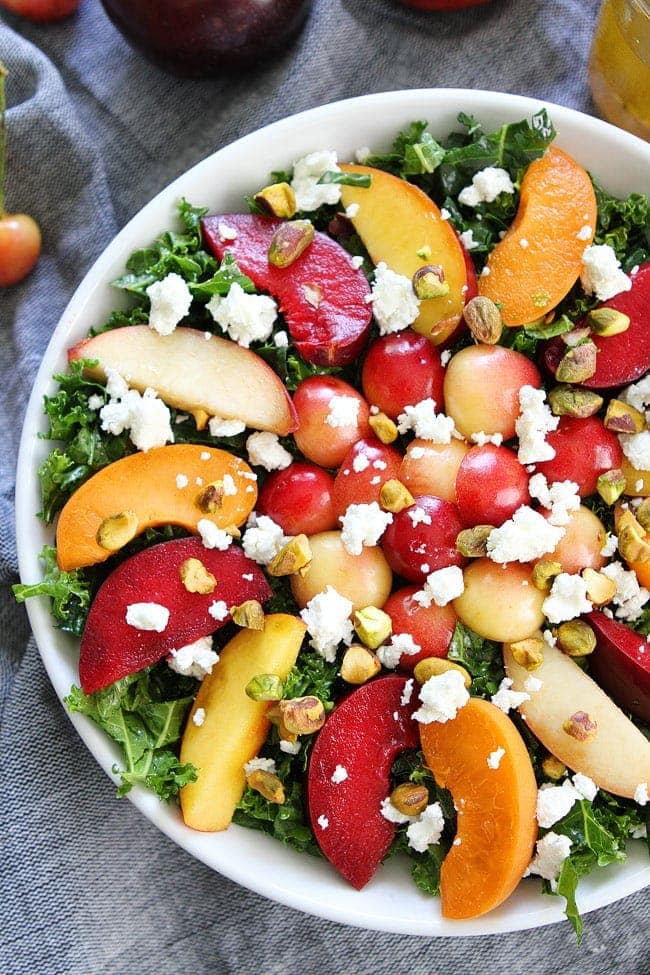 Stone Fruit Kale Salad Recipe on twopeasandtheirpod.com This gorgeous kale salad is loaded with summer stone fruit, goat cheese, and pistachios. It is the perfect side to all of your summer meals. Stone Fruit Kale Salad Recipe