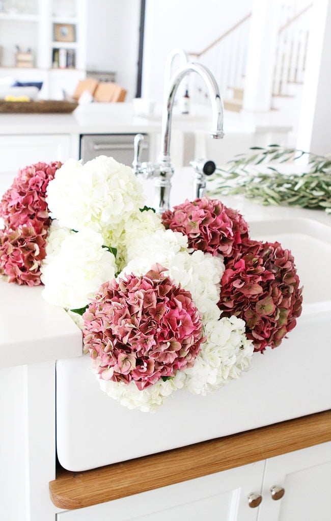 White Kitchen with farmhouse sink on twopeasandtheirpod.com You will love everything about this kitchen! White Kitchen