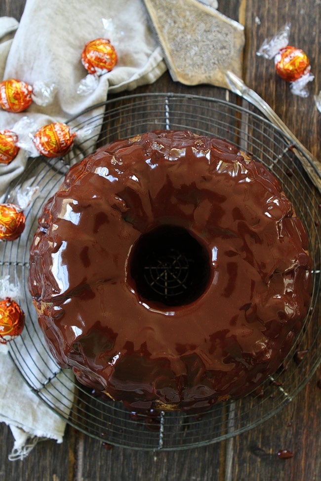 Pumpkin Truffle Bundt Cake with Chocolate Ganache Recipe on twopeasandtheirpod.com Pumpkin bundt cake with chocolate ganache and a tunnel of pumpkin spice truffles inside! The BEST pumpkin cake recipe! Pumpkin Truffle Bundt Cake with Chocolate Ganache Recipe