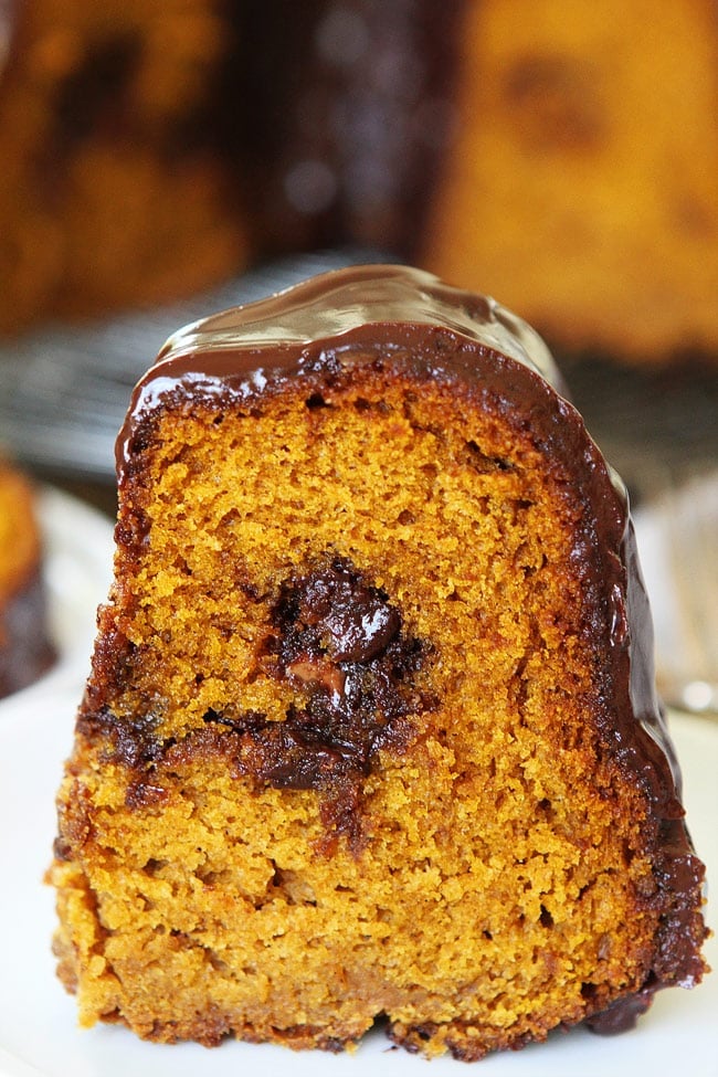 Pumpkin Truffle Bundt Cake with Chocolate Ganache Recipe on twopeasandtheirpod.com Pumpkin bundt cake with chocolate ganache and a tunnel of pumpkin spice truffles inside! Everyone LOVES this pumpkin cake! Pumpkin Truffle Bundt Cake with Chocolate Ganache Recipe