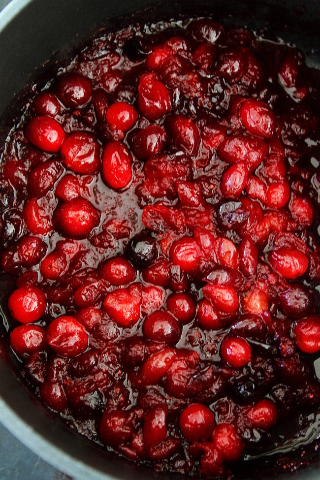 Maple Cranberry Sauce Recipe-Fresh cranberry sauce sweetened with pure maple syrup, orange zest, orange juice, and a hint of cinnamon. This is the BEST cranberry sauce recipe! Fresh cranberry sauce in pan.
