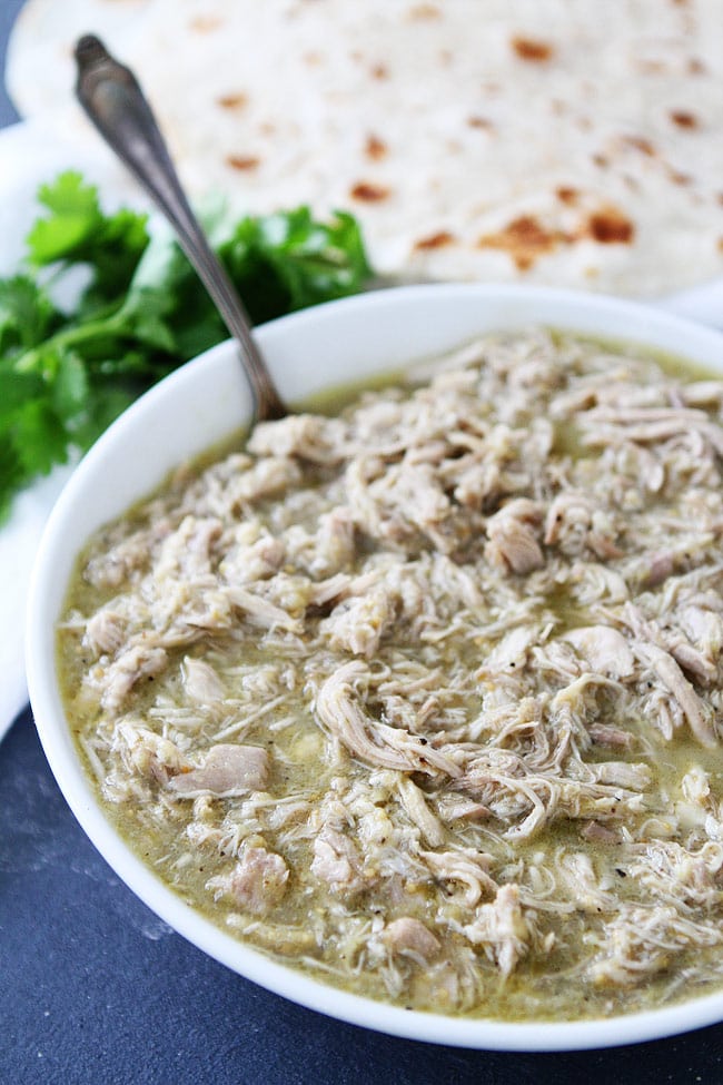 4-Ingredient Instant Pot Chicken Chile Verde Recipe on twopeasandtheirpod.com This easy Instant Pot chicken recipe is a weeknight favorite! chicken chile verde in bowl ready to serve with tortillas