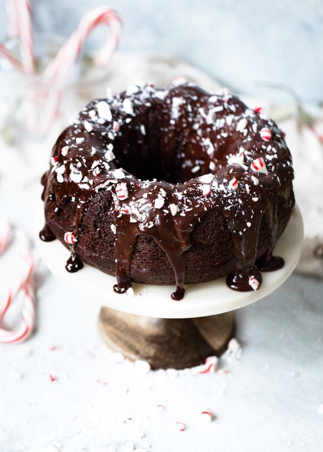 Chocolate Peppermint Bundt Cake Recipe on twopeasandtheirpod.com Moist chocolate sour cream bundt cake drizzled with a silky smooth chocolate glaze and garnished with crushed peppermint candies. This cake is the perfect holiday dessert! Chocolate Peppermint Bundt Cake with chocolate glaze and peppermint candies.