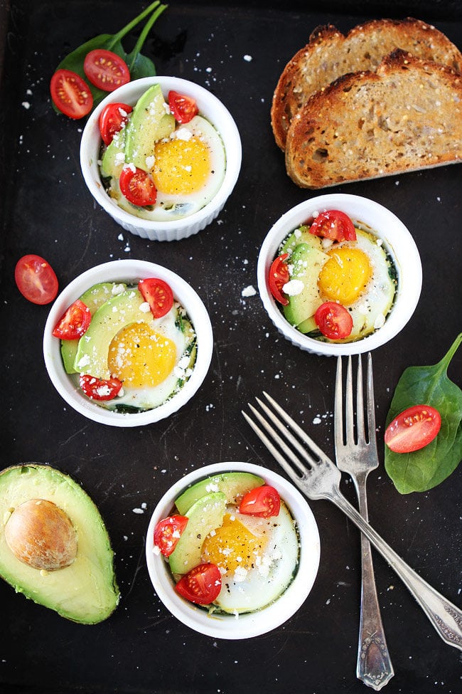 Baked Eggs with Spinach topped with avocado, tomatoes, and crumbled feta cheese makes a great easy breakfast. Serve with toast! Baked Spinach and Eggs topped with avocado and tomato with toast