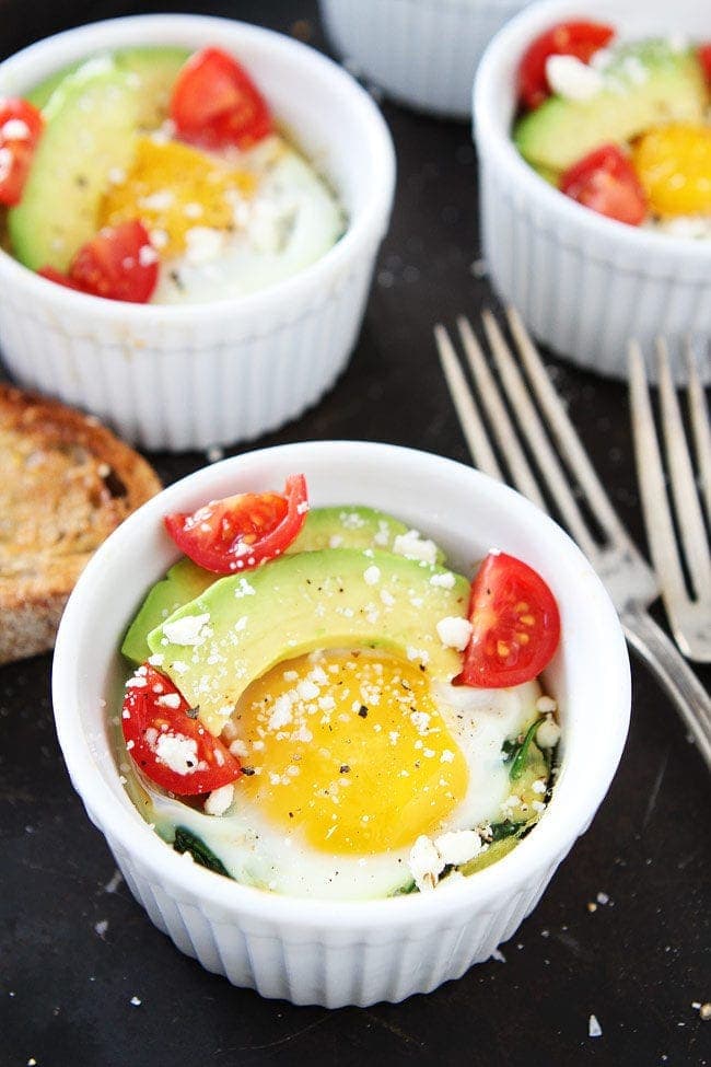 Baked Eggs with Spinach topped with avocado, tomatoes, and crumbled feta cheese makes a great breakfast for every day or easy entertaining. Baked Eggs with Spinach topped with avocado, tomatoes, and crumbled feta cheese
