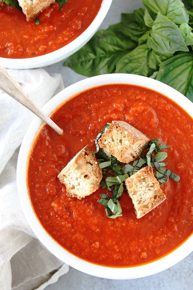 Roasted Red Pepper Tomato Soup Recipe on twopeasandtheirpod.com This simple and satisfying tomato soup is made with pantry staples and takes less than 30 minutes to make. Roasted Red Pepper Tomato Soup in bowl with spoon.