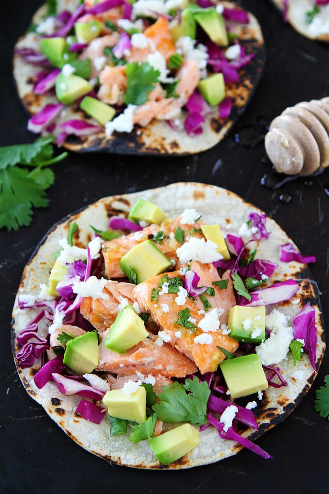 Honey Lime Salmon Tacos Recipe on twopeasandtheirpod.com These easy fish tacos take less than 30 minutes to make! They are great for Taco Tuesday or any day! Healthy salmon fish tacos piled with veggies