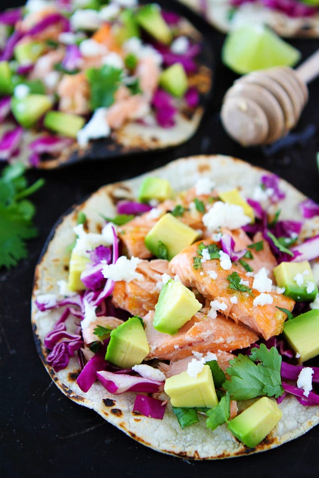 Honey Lime Salmon Tacos Recipe on twopeasandtheirpod.com These easy salmon tacos take less than 30 minutes to make! They are perfect for Taco Tuesday or any day! Salmon fish tacos loaded with toppings
