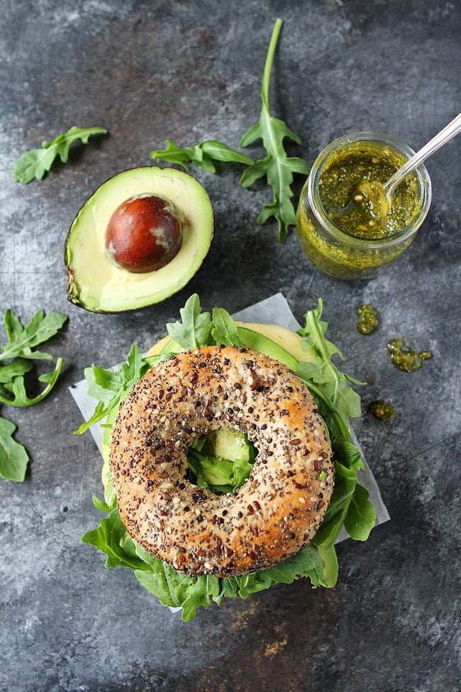 This easy Egg, Avocado, and Pesto Bagel Sandwich with cheese and arugula can be made in 10 minutes. It's so easy and so good! Egg, Avocado, and Pesto Bagel Sandwich with arugula.