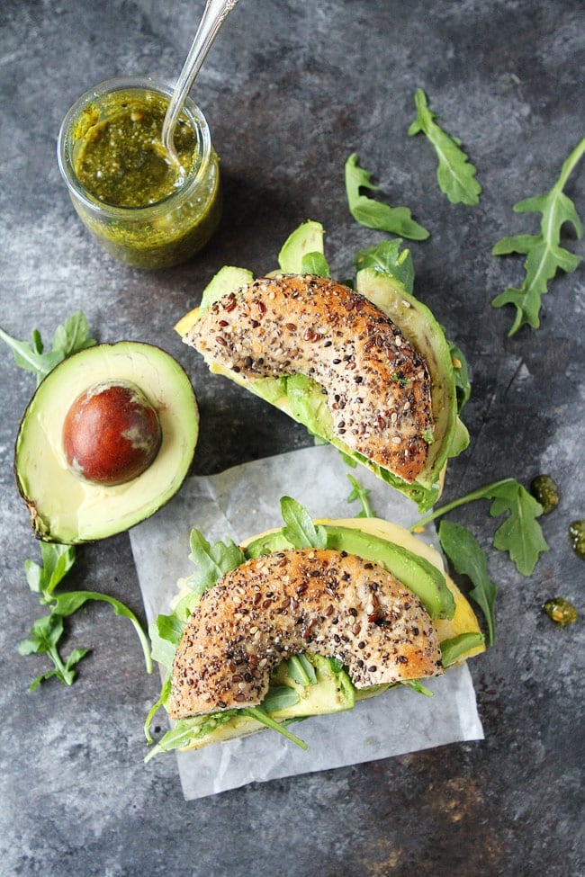 This easy Egg, Avocado, and Pesto Bagel Sandwich with cheese and arugula can be made in 10 minutes. It's great for breakfast or lunch. Egg, Avocado, and Pesto Bagel Sandwich cut bagel.