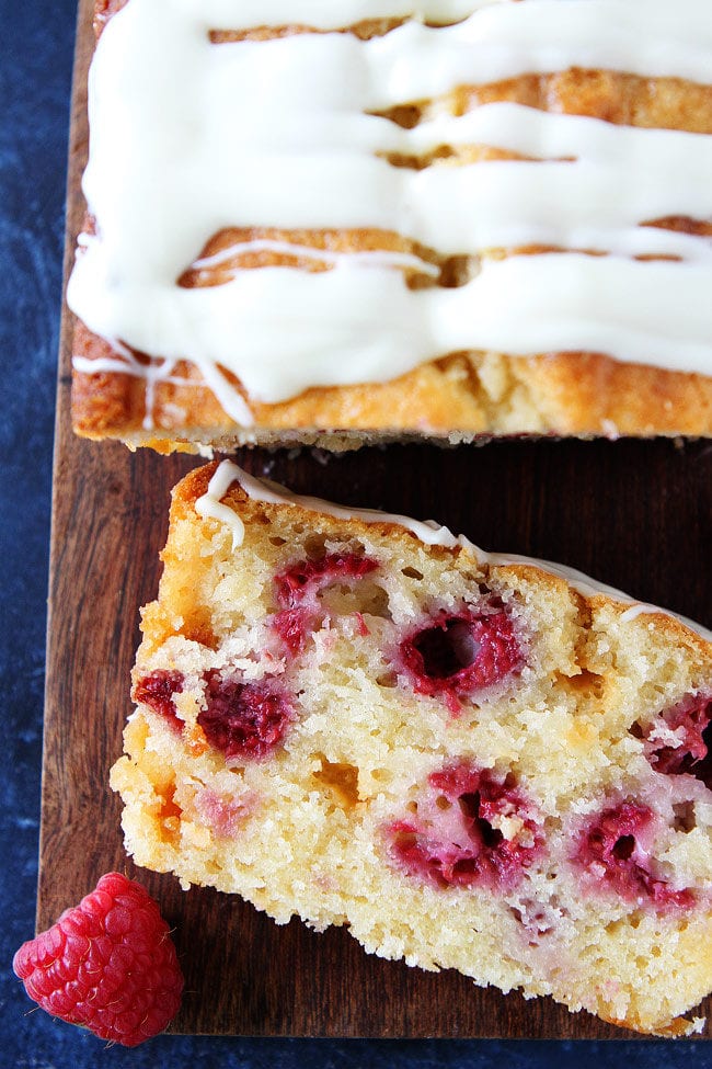 Raspberry White Chocolate Loaf Cake with fresh raspberries, white chocolate chunks, and a sweet white chocolate glaze. An easy summer dessert!
