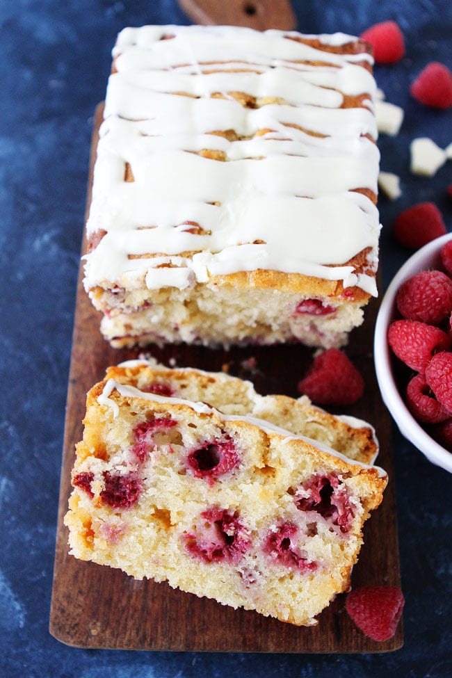 Raspberry White Chocolate Loaf Cake is dotted with fresh raspberries, white chocolate chunks, and finished with a sweet white chocolate glaze.
