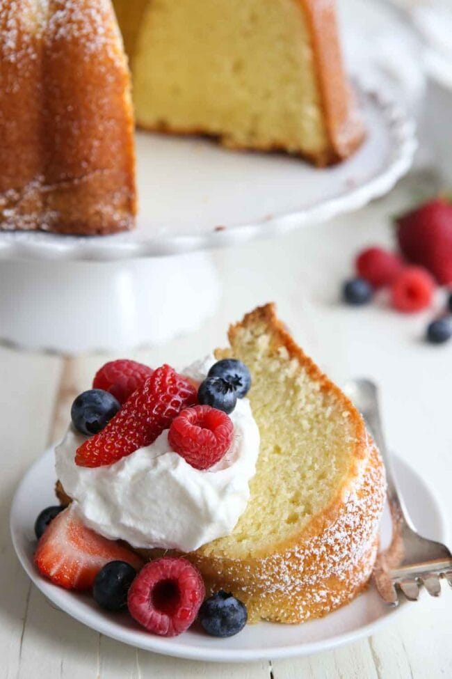 This easy Cream Cheese Pound Cake is a family favorite dessert and the perfect cake for any celebration. pound cake recipe made with cream cheese and served with berries