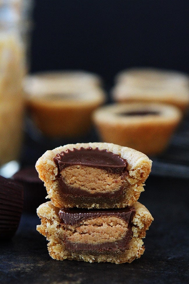 peanut butter cookie cut in half stacked on top of each other showing the peanut butter cup.